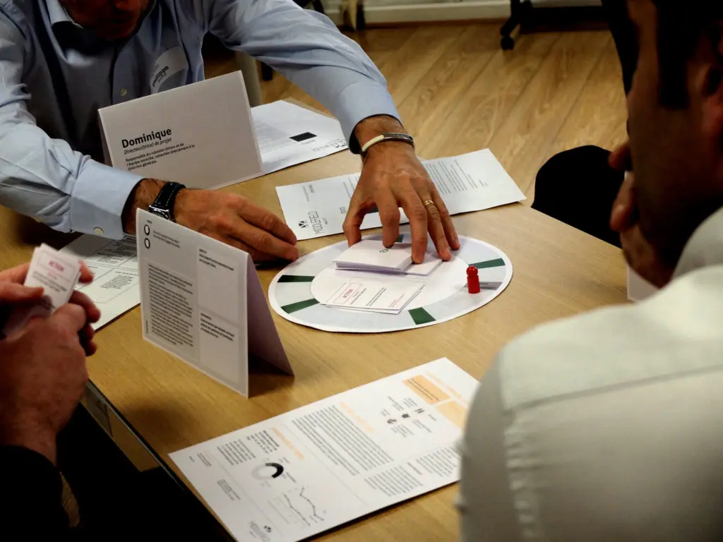 Personnes autour d'une table jouant avec un plateau et des cartes